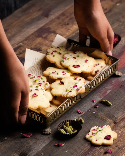 A hand holding cardamom rose cookies